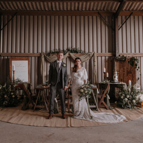 Wedding couple in barn at Seales Hollow. Natural greens sustainable wedding.