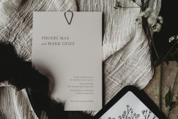 Stone and black minimal wedding invitation with gypsophila detail. Monotone stationery